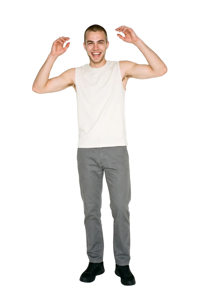 A 20-year-old Caucasian man is shown full body from the front wearing black running sneakers. He is laughing with his arms overhead against a pure white backdrop.