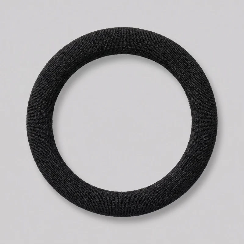 A complete black hair elastic is shown alone in a top-down view. It has a continuous rounded ring shape with a tubular profile and dense ribbed texture around the full circumference, without a visible clasp, logo, print, embroidery, or embellishment.