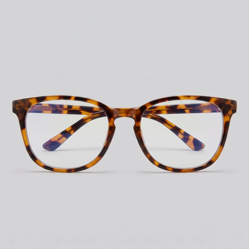 Standalone front view of women's full-rim blue-light glasses with clear, softly squared rectangular lenses, rounded lower corners, a defined brow line, and slightly upswept outer corners. The frame has a molded bridge with an open nose area, thick mottled-pattern rims and temples, visible hinge blocks, and straight temples folded behind the lenses with curved tips visible through them. No logos or embellishments are visible.