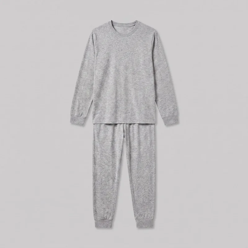 A two-piece grey marl pyjama set is laid flat in a front view, with a long-sleeve crewneck top positioned over matching jogger pants. The top has ribbed sleeve cuffs and a straight hem, while the pants taper toward the ankles and have ribbed ankle cuffs. The fine marled flecked surface is visible across the set.