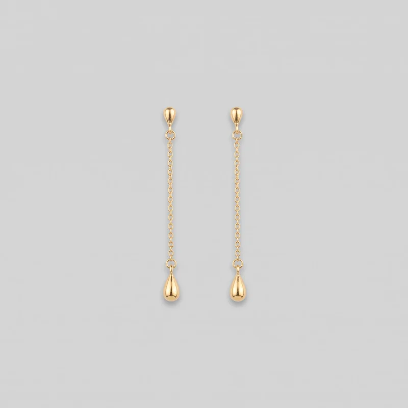 A pair of matching gold drop earrings is laid out side by side. Each earring has a smooth teardrop-shaped top stud, a short connector, a circular ring, a straight chain of oval links, and a larger teardrop-shaped pendant suspended below.
