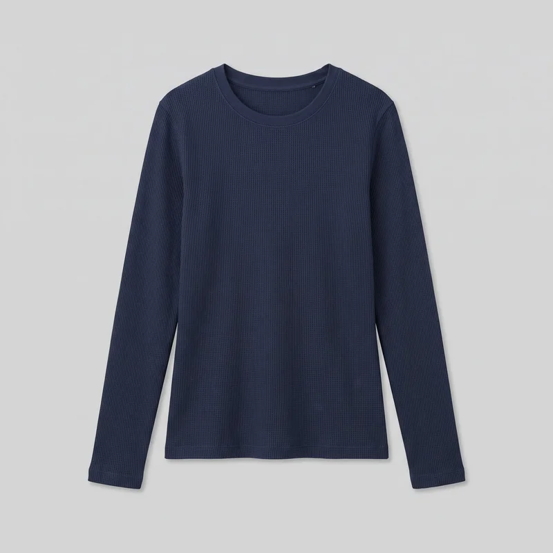A navy long-sleeve thermal top is shown flat as a standalone product, viewed from the front. It has a rounded crew neckline with a bound band and visible stitching, an all-over vertical ribbed knit texture, set-in shoulders, a regular straight silhouette, a full-length body, and long straight sleeves. The straight lower hem and sleeve cuffs have stitched finishes, with no visible closures, pockets, logos, prints, patches, embroidery, or embellishments.