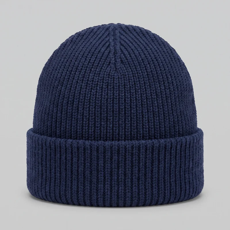 A navy ribbed knit cuff beanie is shown as a standalone front view. Its rounded close-fitting dome, wide folded lower cuff, and continuous vertical knit ribs are mostly visible, with the ribs tapering together toward the crown.