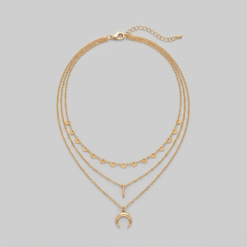 A standalone flat view of a women's gold layered necklace with multiple fine-link chain loops. The necklace includes a shorter strand with evenly spaced flat round disc charms, a lower strand with a slim vertical bar pendant, and a longest strand with a crescent-shaped pendant. The back closure includes a lobster-claw clasp, jump-ring connections, and an extender chain ending in a teardrop-shaped tip.