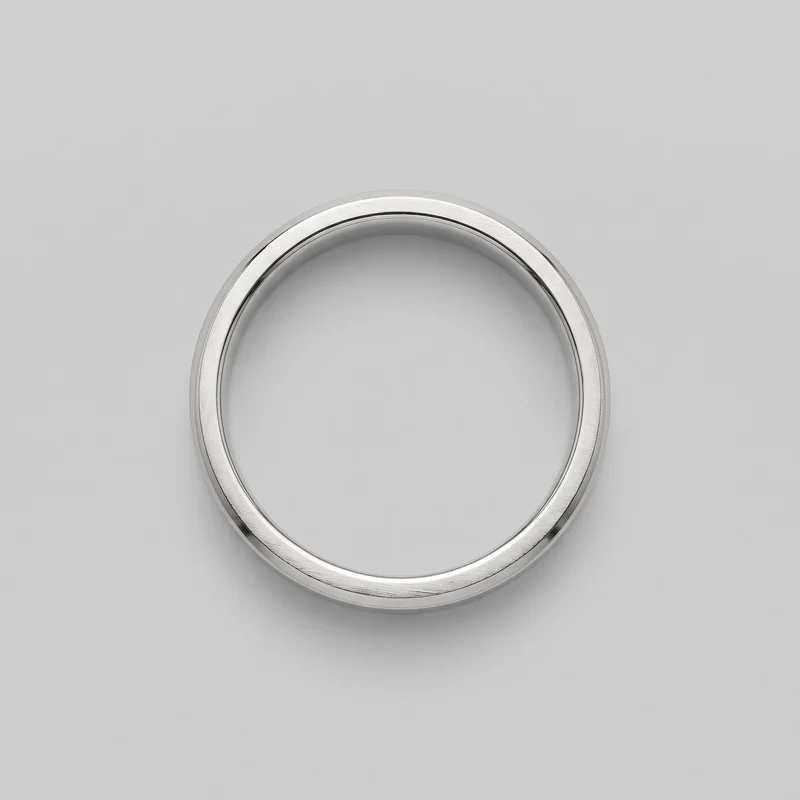 A complete circular men's platinum wedding band is shown from above against a plain backdrop. The ring has a flat satin-brushed outer face, raised beveled outer edges, recessed channels bordering the central face, and a smooth rounded inner opening. No stones, settings, logos, prints, closures, or other embellishments are visible.