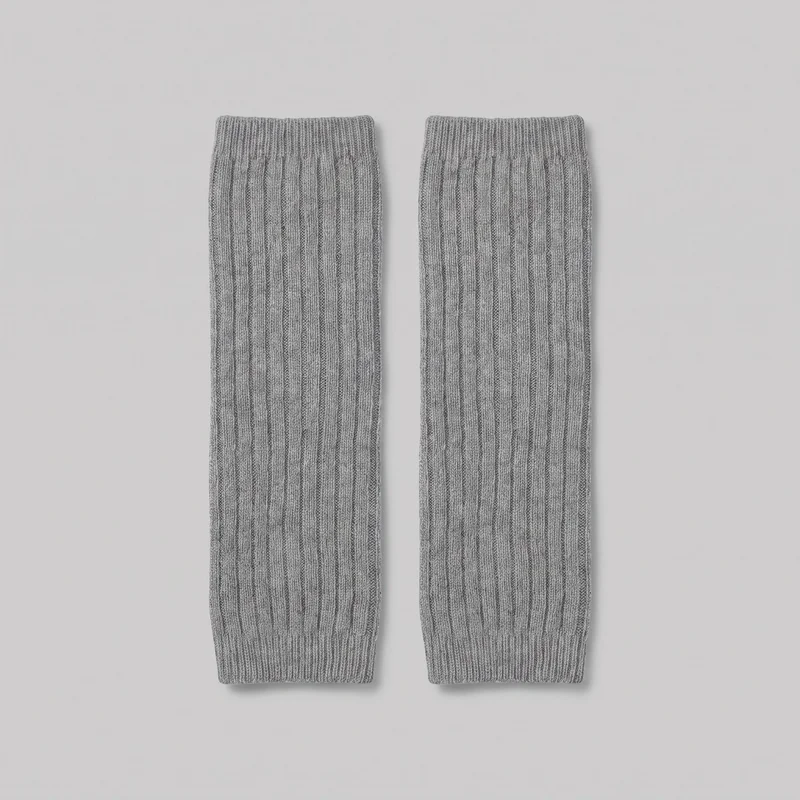 A matching pair of grey ribbed knit leg warmers is laid flat side by side. Each long tubular piece has continuous vertical ribbing and narrower cuffs at both open ends.