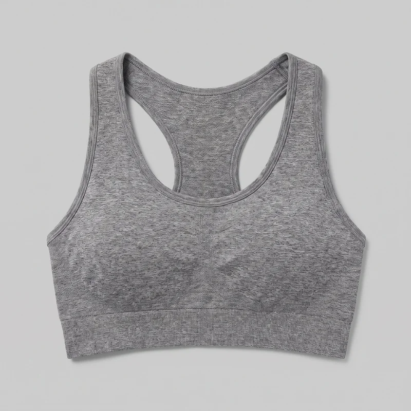 Grey women's racerback sports bra shown laid flat as a standalone product. The view shows its scoop front neckline, sleeveless cut, racerback straps, bound edges, subtle center-front vertical paneling, fine heathered texture, and broad underbust band.