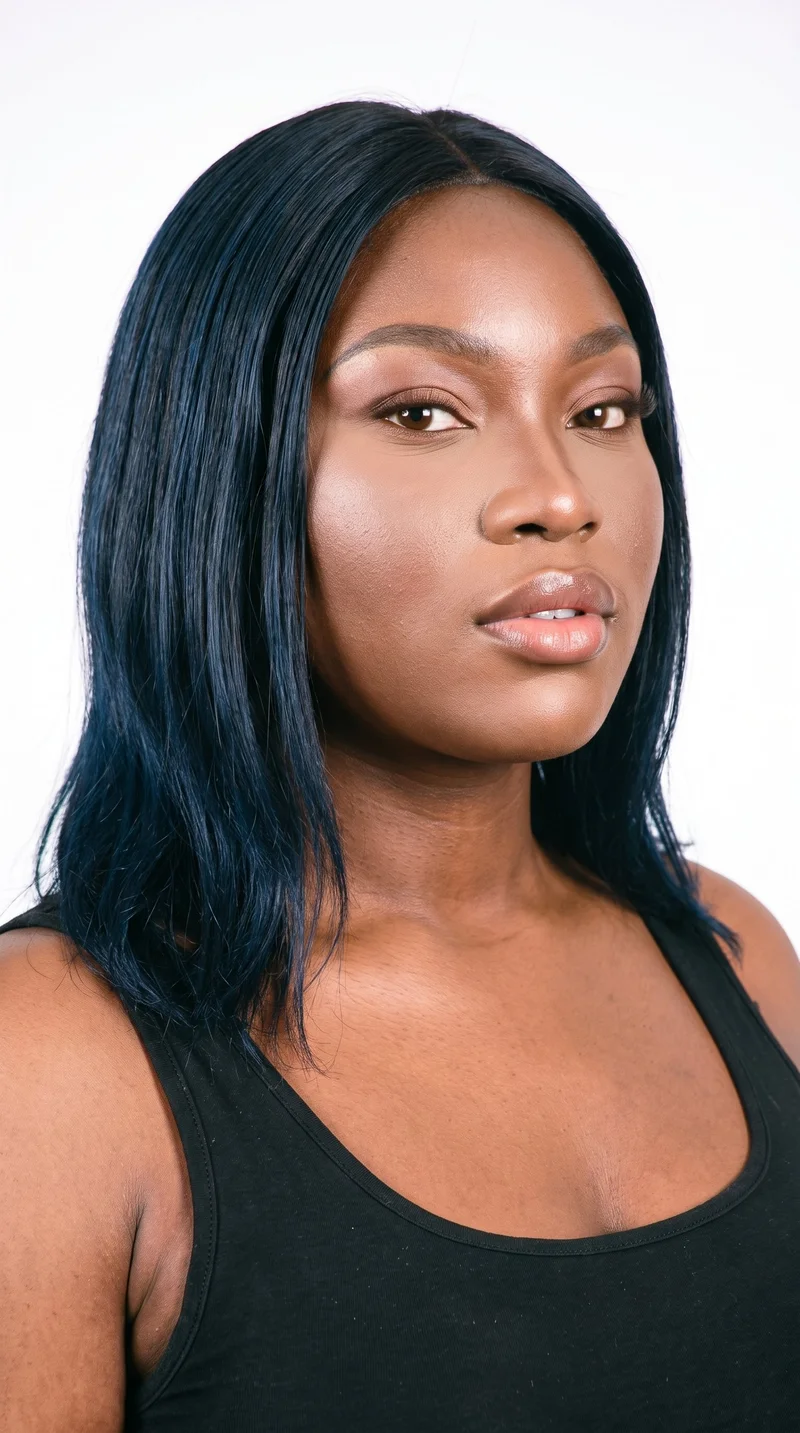 A 21-year-old African woman with copper-brown skin and a neutral reddish-copper undertone. Her diamond-shaped face has a narrow forehead and jawline, with the widest point at the cheekbones. She has medium-thickness eyebrows, brown eyes, and medium lips. Her black hair is naturally textured but straightened into a smooth, glossy silk-press style.