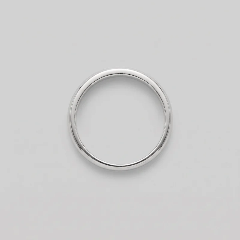 A complete plain silver band ring is shown upright, with its circular opening and rounded domed exterior profile visible. The ring has a smooth, unadorned surface, softly rounded edges, and a simple smooth inner wall, with no visible stones, engravings, logos, settings, closures, or embellishments.