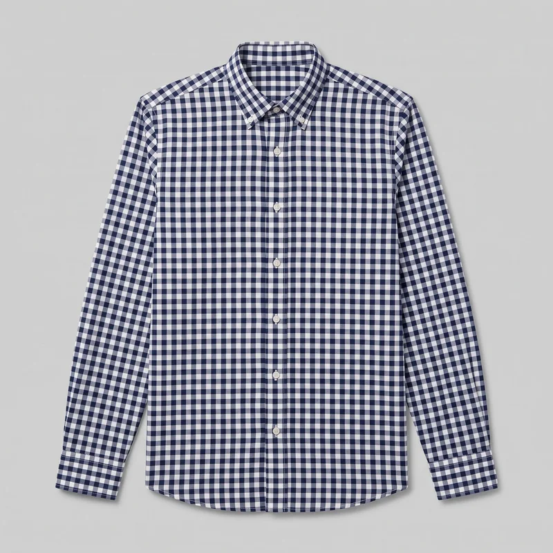 A navy gingham check long-sleeve button-down shirt is shown laid flat in a mostly complete front view. It has a structured point collar, full front button placket, straight shoulder seams, buttoned cuffs, and a gently curved shirttail hem, with no visible chest pockets or embellishments.