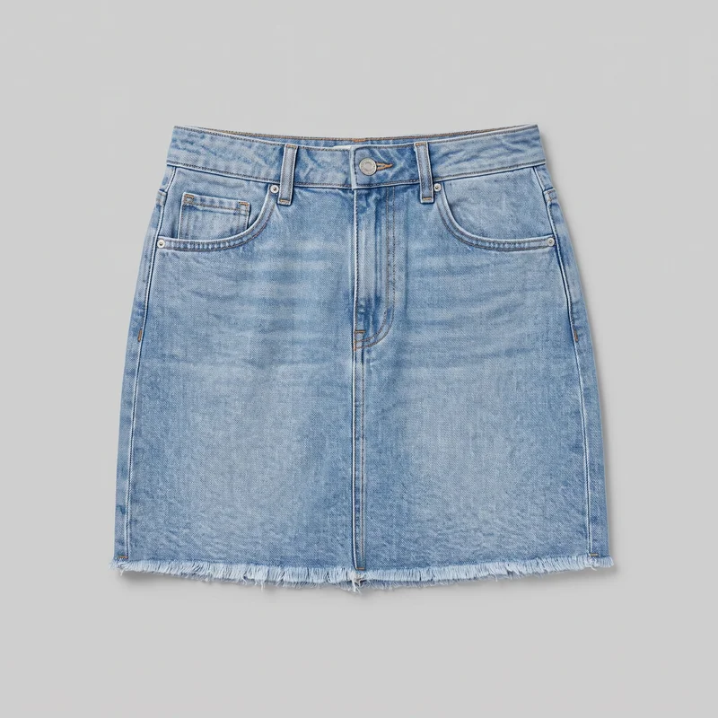 Light wash denim mini skirt laid flat in a mostly complete front view. It has a regular A-line silhouette, straight waistband, exposed button, belt loops, front fly placket, five-pocket jean-style construction with curved front pockets and a coin pocket, metal rivets, contrast topstitching, and a straight raw fringed hem.