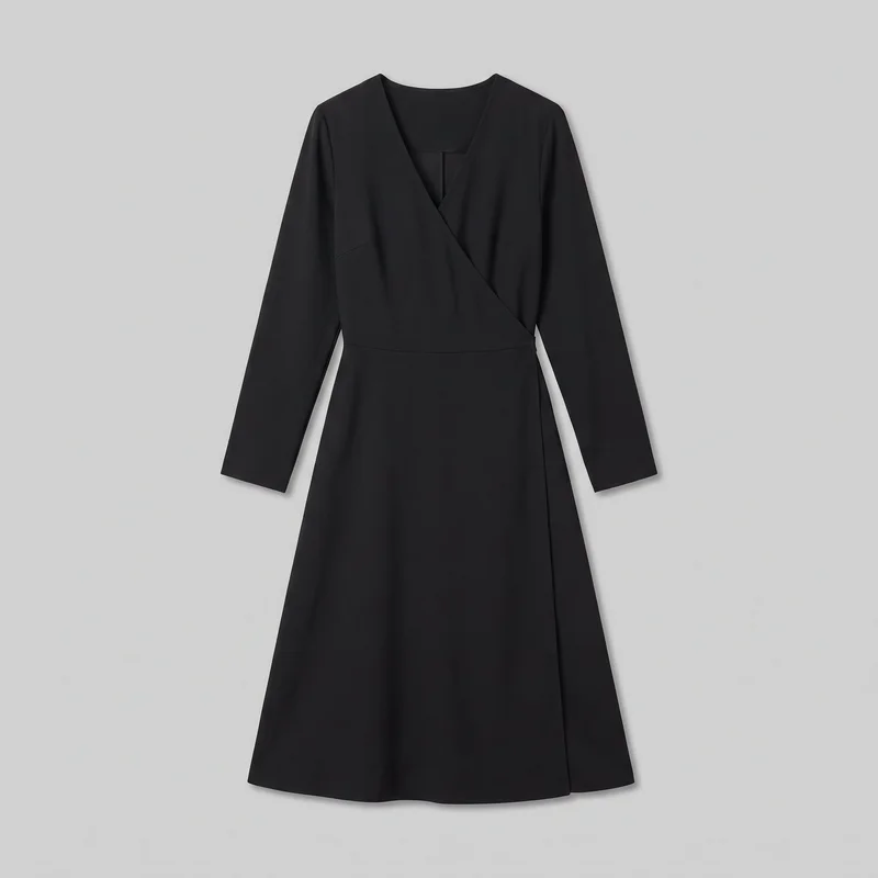 A mostly complete front view of a black wrap-front midi dress laid flat against a backdrop. The dress has a surplice V neckline, tailored bodice and waist, set-in shoulders, straight long sleeves with plain cuffs, a horizontal waist seam, and an asymmetric overlap seam extending down one side of the subtly flared A-line skirt.