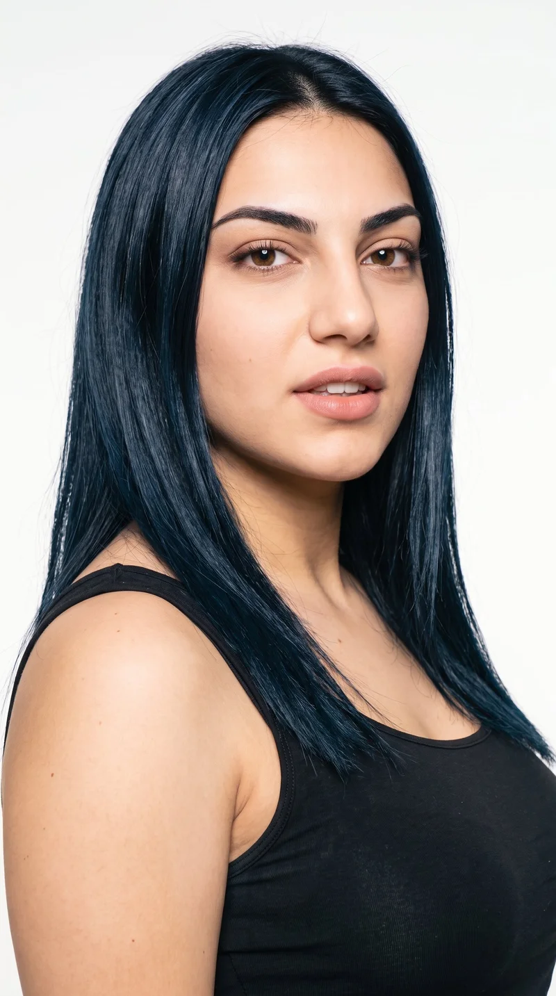 This 19-year-old Turkish woman has an olive, medium-toned complexion with a neutral greenish-golden undertone. Her heart-shaped face has a wider forehead that narrows to a more pointed chin, framed by medium-thick eyebrows. She has brown eyes and full lips. Her deep black hair is straight, smooth, and parted evenly at the centre.