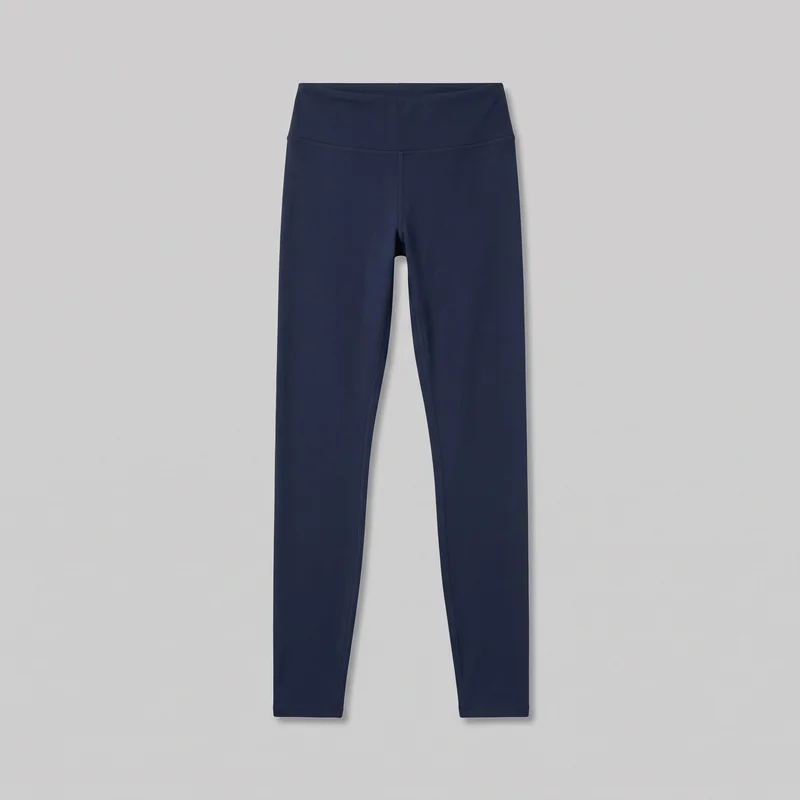 Navy full-length active leggings are shown in a complete front flat-lay view, centered without a model or mannequin. They have a high rise, bodycon fit, broad smooth waistband, slim straight legs, flat narrow hems, and visible stitched seams including a curved seam below the waistband, center front rise seam, inner-leg seams, and hem stitching. No closures, pockets, logos, prints, patches, embroidery, or embellishments are visible.