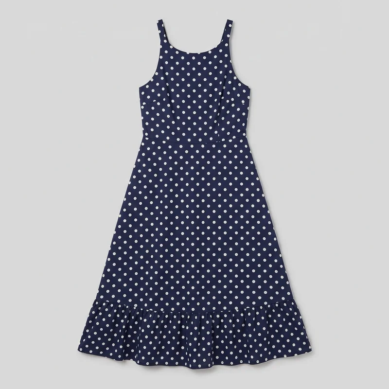 A complete navy sleeveless midi dress is arranged in a flat-lay front view. It has wide shoulder straps, a rounded scoop neckline, a tailored bodice with a defined horizontal waist seam, and a long A-line skirt that flares away from the body. An evenly spaced all-over polka-dot print covers the dress, which finishes with a gathered lower ruffle tier and softly wavy hem.