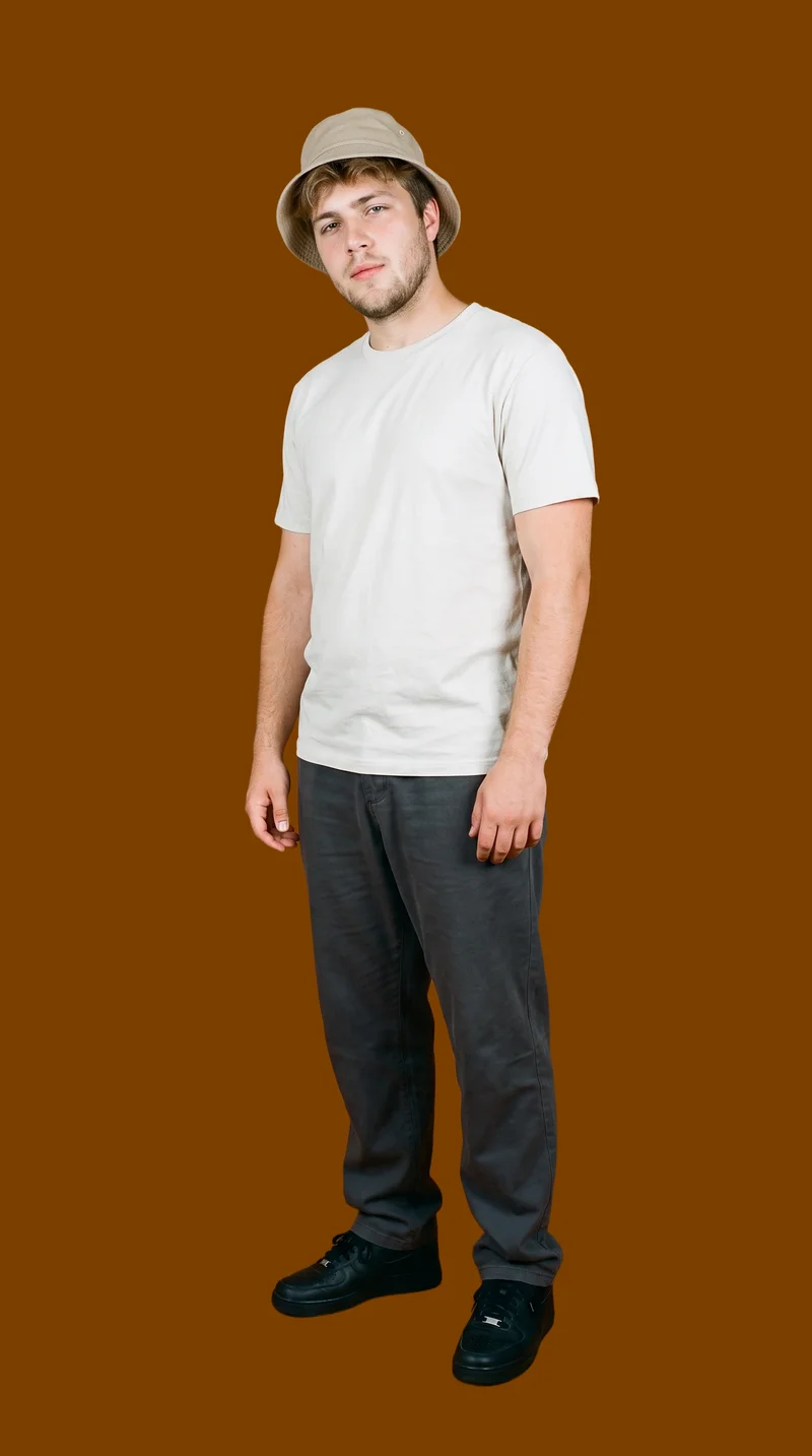 An 18-year-old Caucasian man wears a beige bucket hat in a relaxed standing pose, shown from a front three-quarter angle with a soft facial expression. The environmental composition uses a chocolate-brown flat-color backdrop.