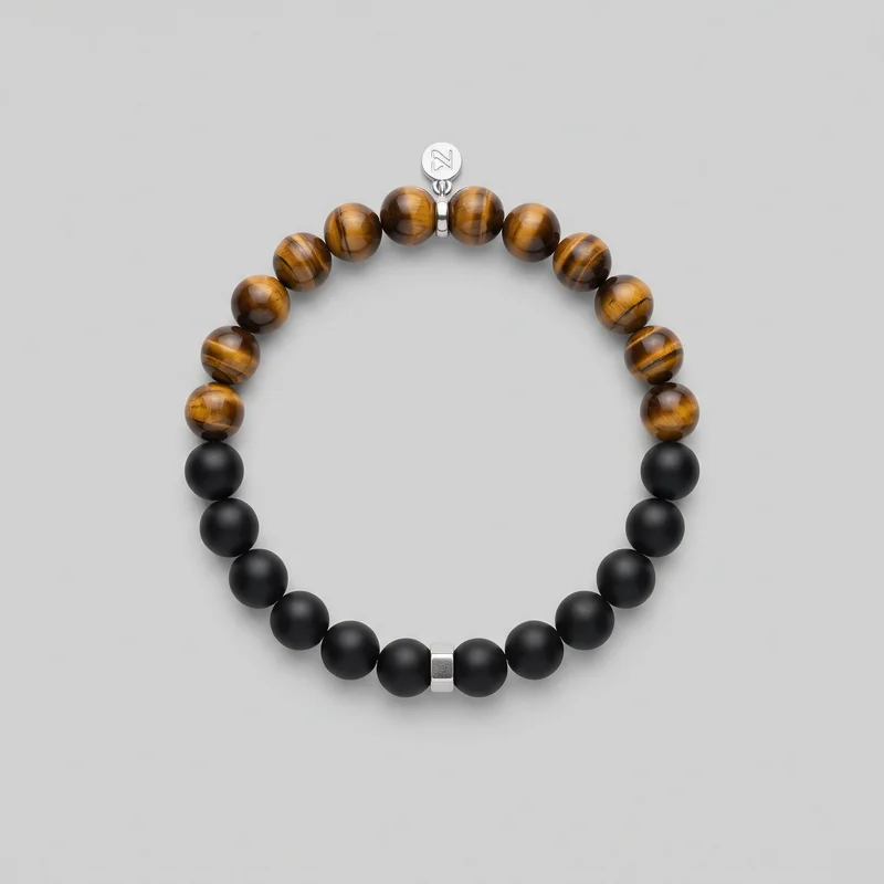 A complete men's beaded bracelet is arranged in a circular shape. Smooth matte solid beads form the lower section, while glossy, banded, translucent-looking round beads form the upper section. A rectangular metallic spacer sits at the bottom center, and a small metallic connector assembly with a round logo charm is visible at the top.