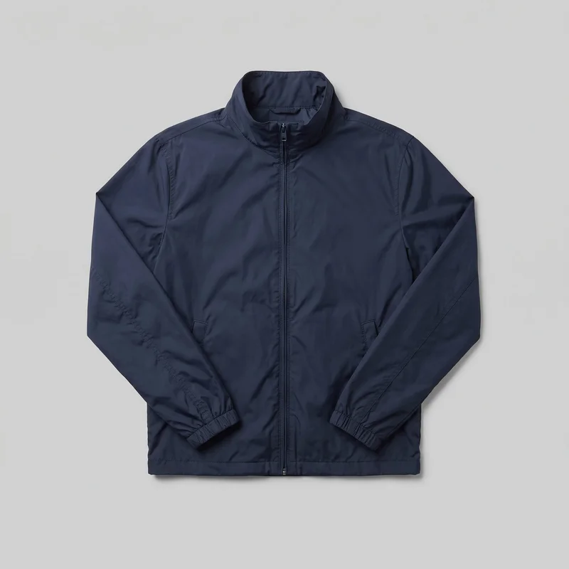 A mostly complete front flat-lay view of a men's navy windbreaker jacket. It has a regular fit, a hip-length straight body, a high stand collar, long sleeves with elasticated cuffs, a full-length center zipper, two slanted lower-front welt hand pockets, curved shoulder and upper-sleeve seam panels, and a straight stitched hem. Visible topstitching follows the collar, shoulders, sleeve seams, pockets, cuffs, and hem; no logos, prints, patches, embroidery, or embellishments are visible.